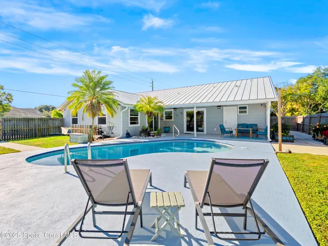 a view of a house with swimming pool and sitting area