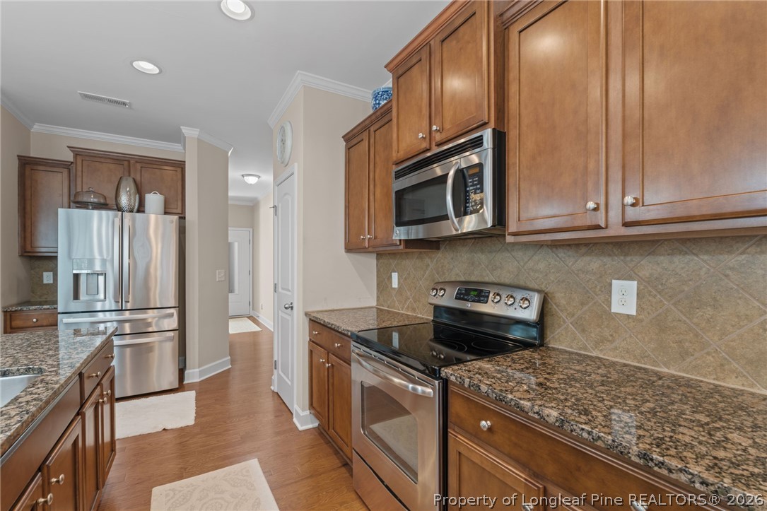 126 Pine Hawk Drive Spring Lake, NC 28390 - Photo 14 of 48 a kitchen with stainless steel appliances granite countertop a stove microwave and refrigerator