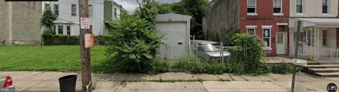 a backyard of a house with potted plants and palm trees