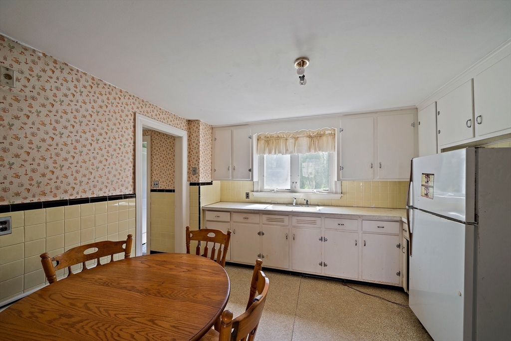 11 Latin Road Boston, MA 02132 - Photo 3 of 30 a kitchen with stainless steel appliances granite countertop a refrigerator a sink dishwasher a stove with white cabinets and wooden floor