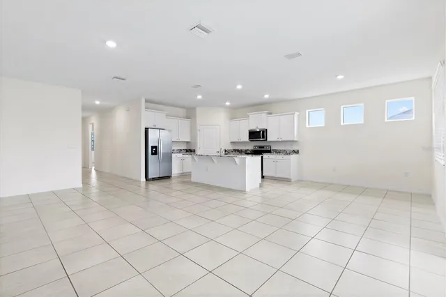 a view of kitchen with stainless steel appliances granite countertop refrigerator sink and cabinets