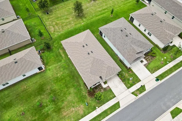 an aerial view of a house with garden space and street view