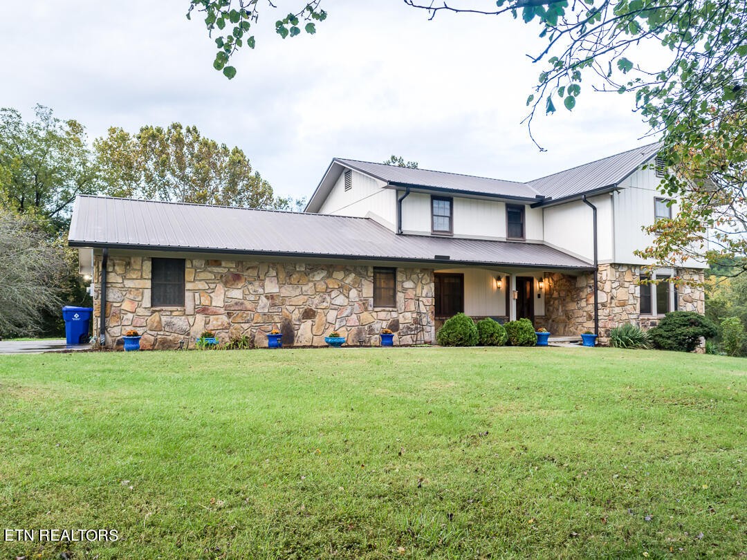 a view of a brick house with a big yard and large trees