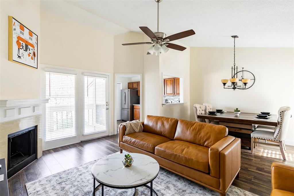 a living room with furniture kitchen view and a wooden floor