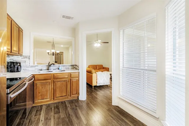 a large white kitchen with sink a refrigerator and white cabinets