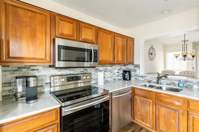 a kitchen with stainless steel appliances granite countertop a stove microwave and sink