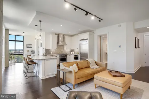 a kitchen with stainless steel appliances granite countertop a stove refrigerator and a view of living room