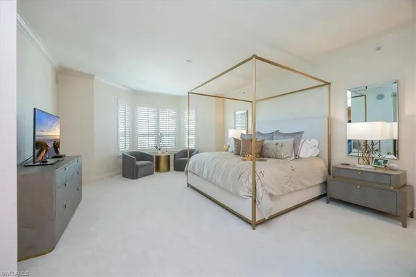 a bedroom with a white bed couch and a window