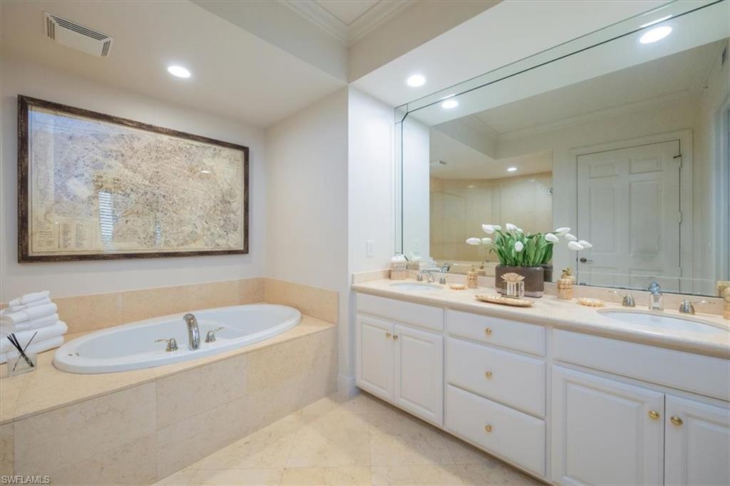 285 Grande Way, Unit 706 Naples, FL 34110 - Photo 13 of 24 a bathroom with a tub a sink and mirror