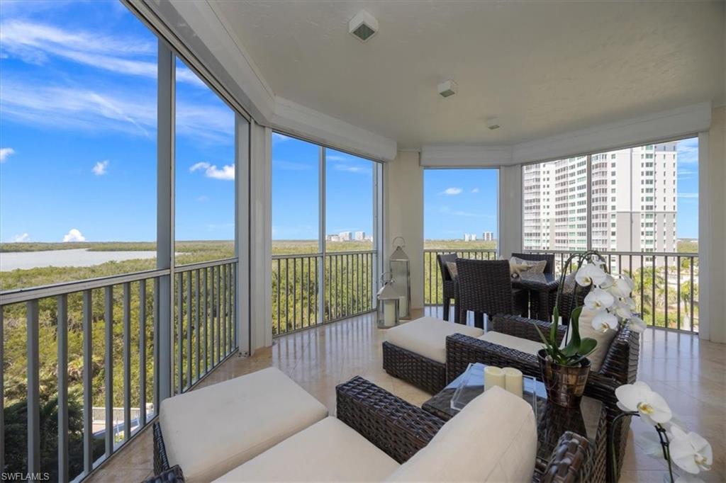 285 Grande Way, Unit 706 Naples, FL 34110 - Photo 22 of 24 a living room with furniture floor to ceiling window and wooden floor
