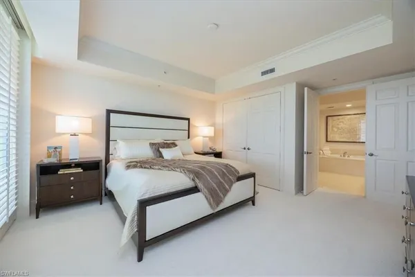 a spacious bedroom with a bed and cabinets