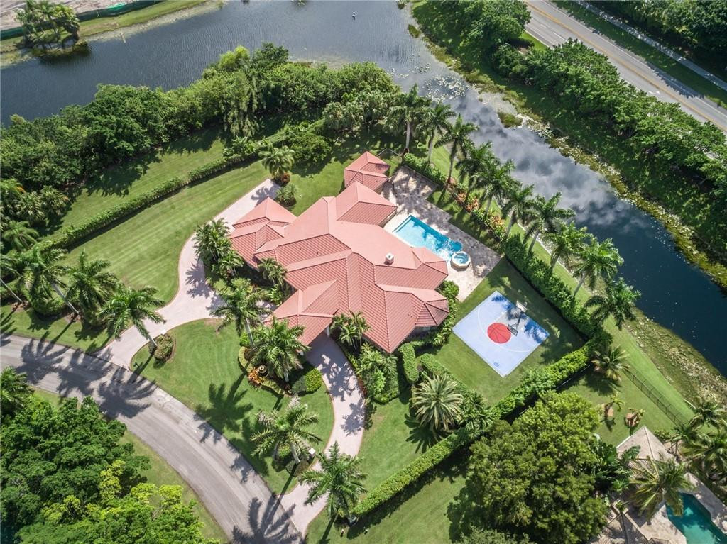 an aerial view of a house with swimming pool and garden