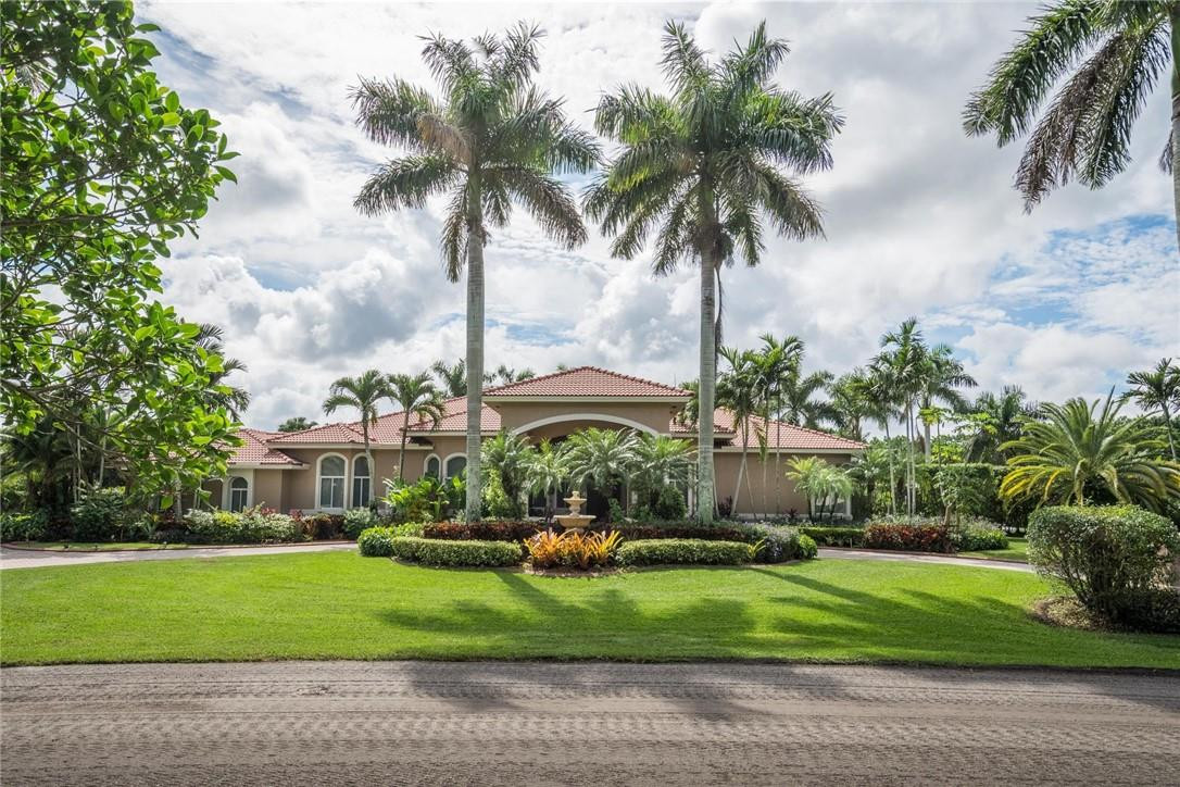 3620 Paddock Road Weston, FL 33331 - Photo 3 of 51 a front view of a house with a garden and swimming pool