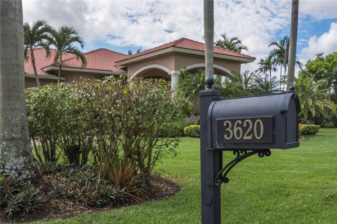 3620 Paddock Road Weston, FL 33331 - Photo 48 of 51 a wooden bench sitting in front of a house