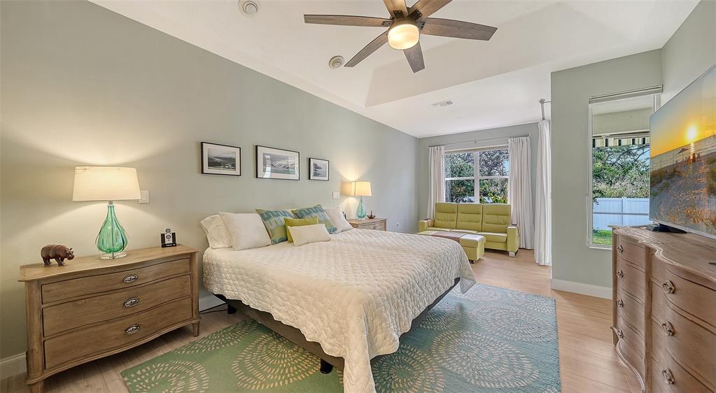 4855 Carrington Circle Sarasota, FL 34243 - Photo 22 of 58 a bedroom with a bed and a flat tv screen on dresser