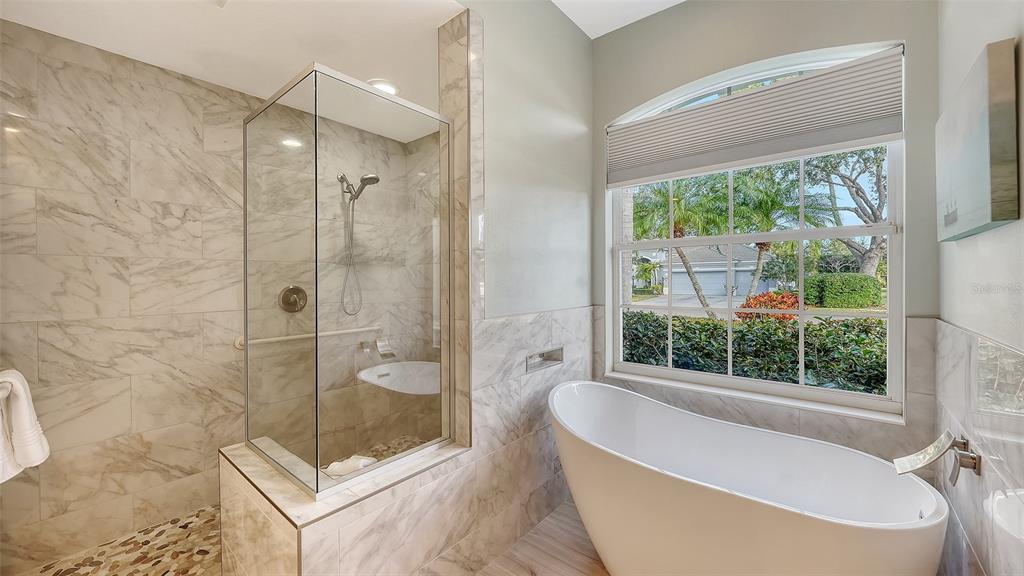 4855 Carrington Circle Sarasota, FL 34243 - Photo 29 of 58 a bathroom with a large tub a shower and view
