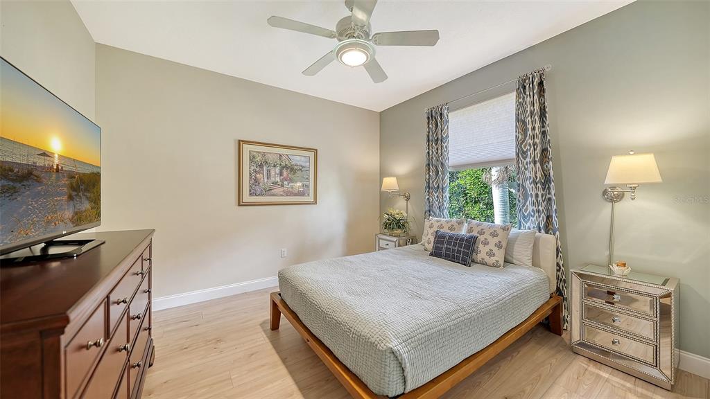 4855 Carrington Circle Sarasota, FL 34243 - Photo 32 of 58 a bedroom with a bed and a flat tv screen on the dresser