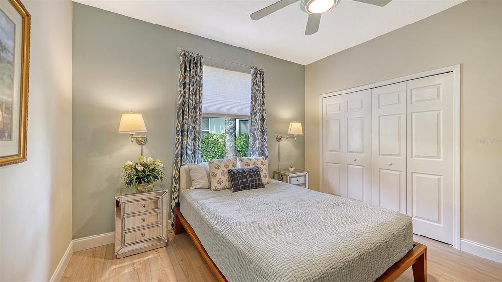 4855 Carrington Circle Sarasota, FL 34243 - Photo 33 of 58 a bedroom with a large bed and a chandelier