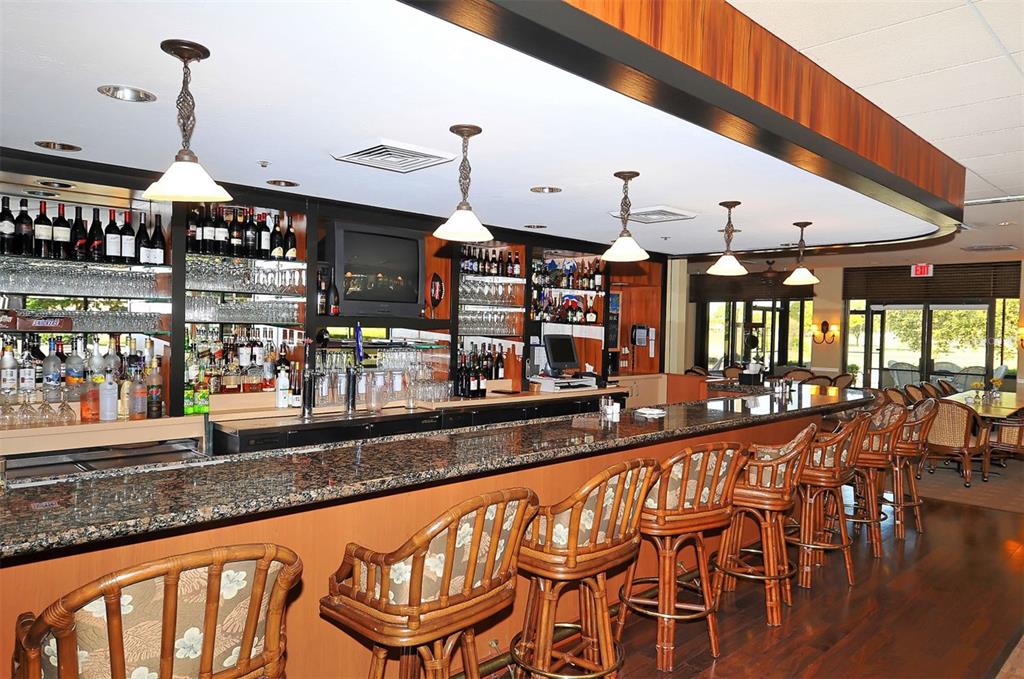 4855 Carrington Circle Sarasota, FL 34243 - Photo 54 of 58 a open kitchen with stainless steel appliances kitchen island granite countertop a table chairs and a wooden floor