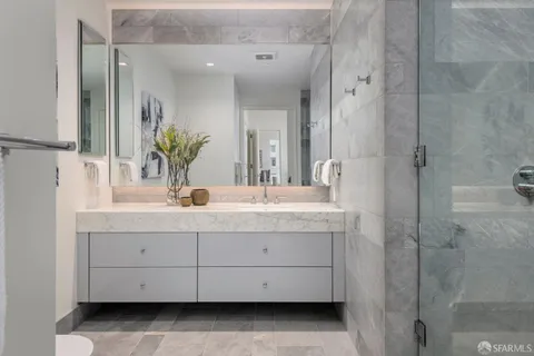a bathroom with a glass door shower and a sink