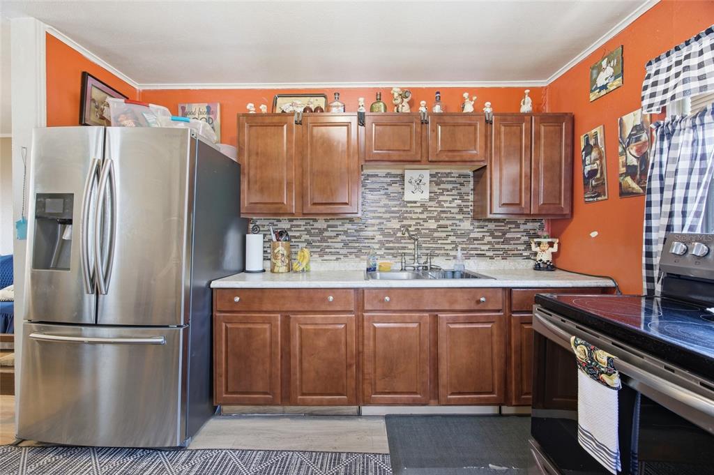 10535 3rd Avenue Ocoee, FL 34761 - Photo 5 of 22 a kitchen with stainless steel appliances granite countertop a refrigerator a stove and a sink