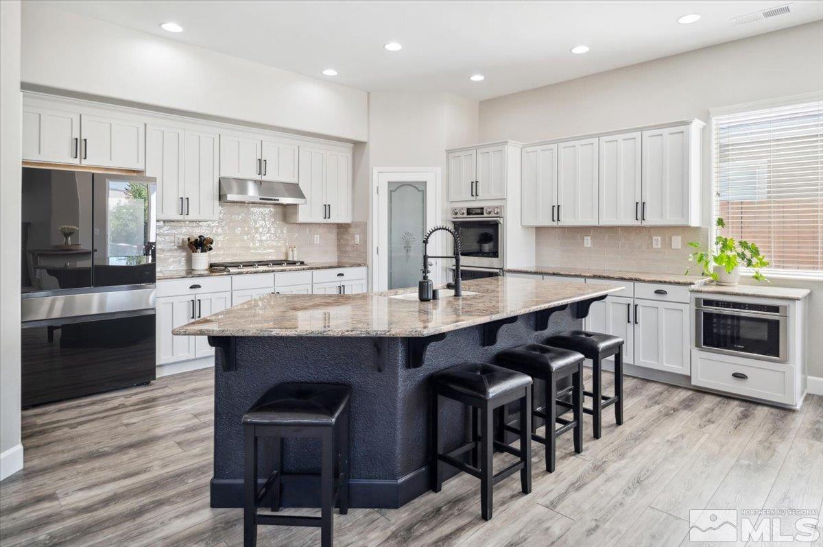 1602 Silver Thread Drive Reno, NV 89521 - Photo 10 of 39 a kitchen with stainless steel appliances a stove a sink a microwave a refrigerator and cabinets
