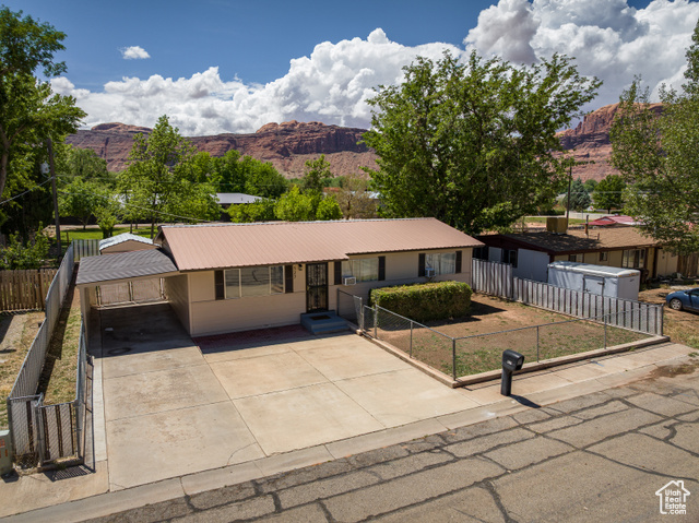 527 Palisade Drive Moab, UT 84532 - Photo 31 of 51 Single story home with a mountain view, driveway, a fenced front yard, metal roof, and an attached carport