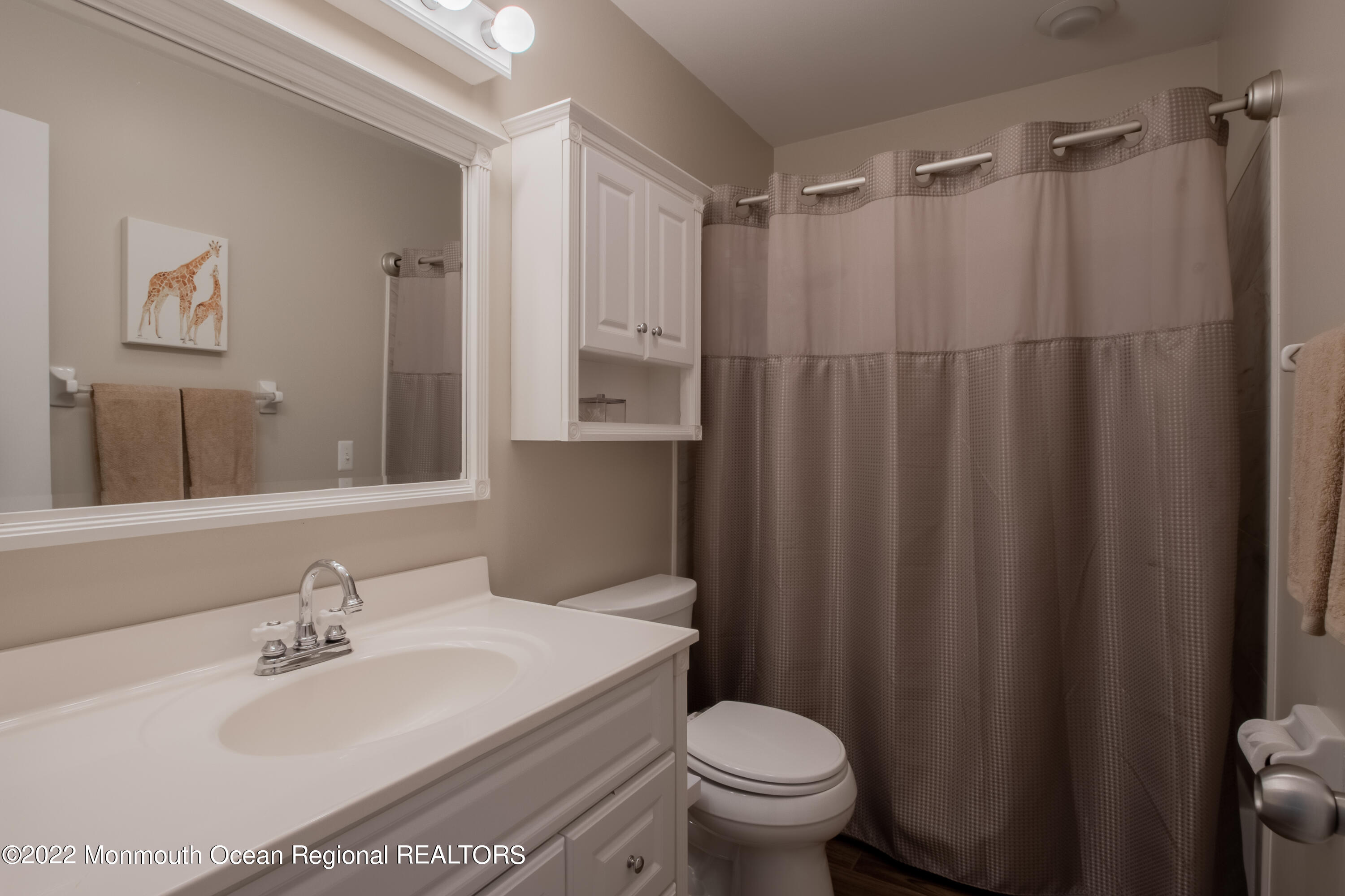 73 Ravine Drive Matawan, NJ 07747 - Photo 13 of 15 a bathroom with a sink a toilet and a mirror
