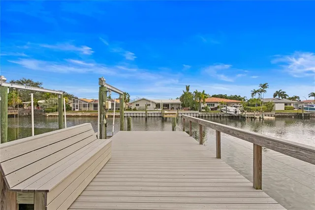 a kitchen with granite countertop a sink a stove a dining table and chairs