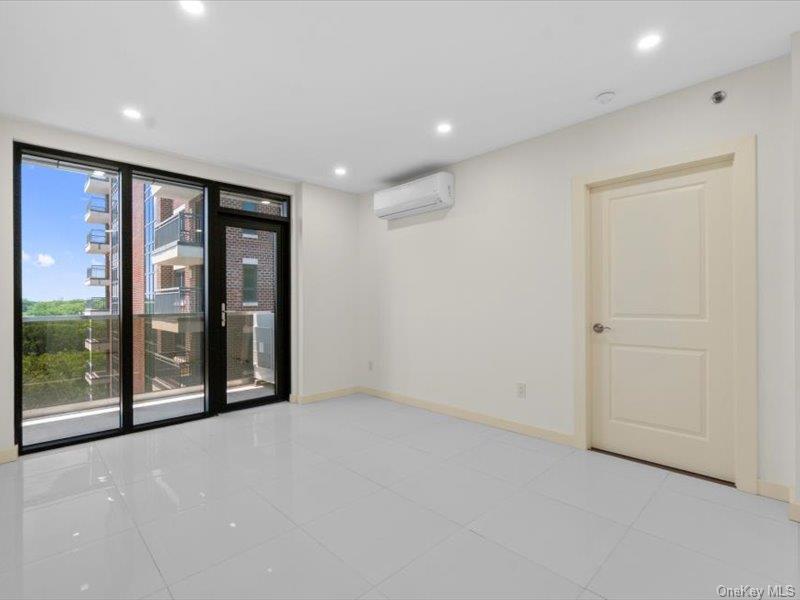 124-28 Queens Boulevard, Unit 12A Queens, NY 11415 - Photo 4 of 16 Unfurnished room with recessed lighting, a wall mounted AC, and light tile patterned floors