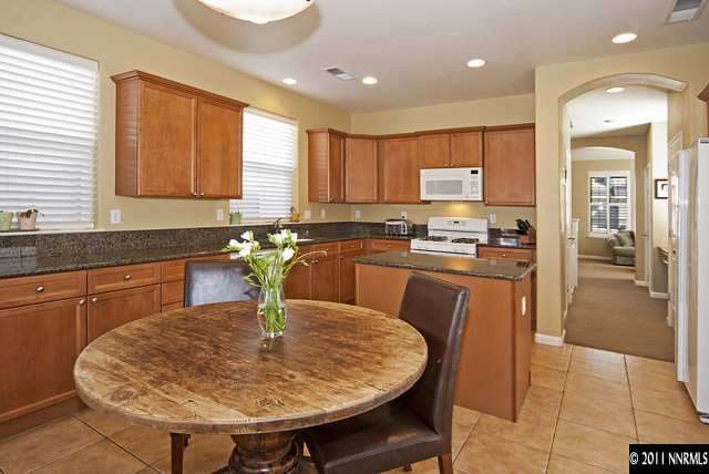 1712 Cavern Drive Reno, NV 89521 - Photo 5 of 13 a kitchen with stainless steel appliances kitchen island granite countertop a sink a stove a dining table and chairs