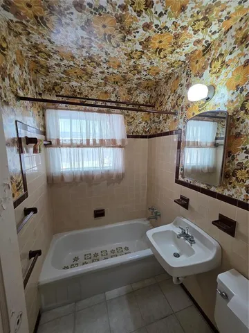 a bathroom with a sink a toilet and mirror