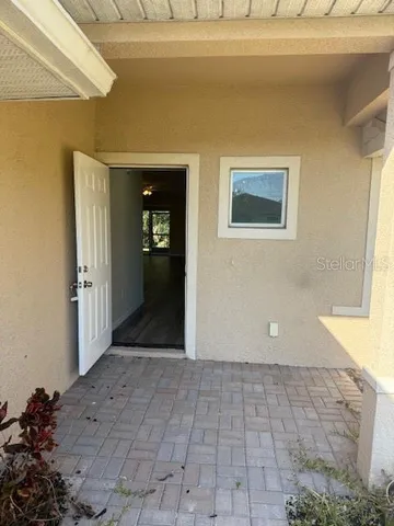a view of a hallway with wooden floor and a living room