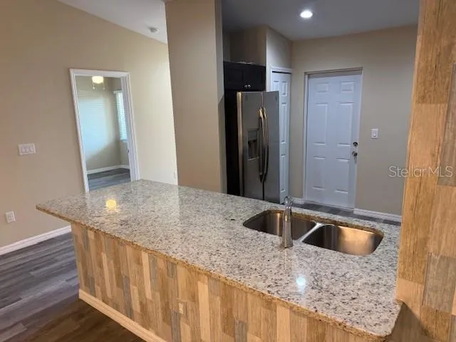 a kitchen with stainless steel appliances granite countertop a sink a refrigerator and a sink