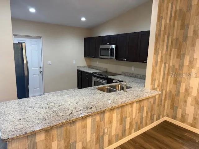 a kitchen with a stove a sink and a microwave