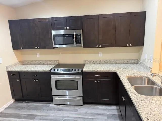 a kitchen with granite countertop wood cabinets and stainless steel appliances