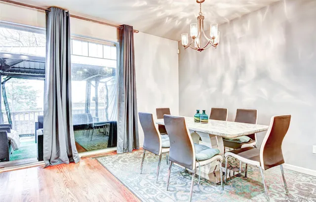 a view of a dining room with furniture a chandelier and wooden floor