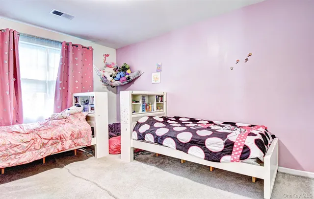 a hallway with painting on the wall and a potted plant