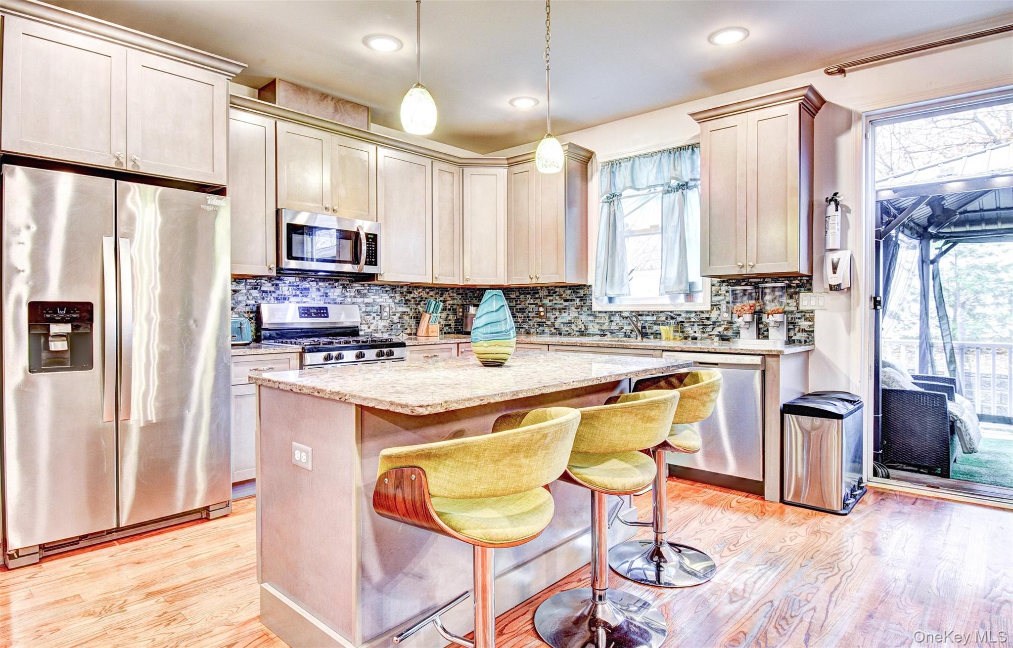 17 Magnolia Park Road Middletown, NY 10940 - Photo 3 of 35 a kitchen with stainless steel appliances kitchen island granite countertop a refrigerator a stove a sink and white cabinets with wooden floor