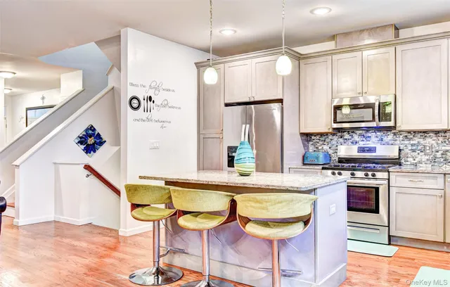 a kitchen with stainless steel appliances granite countertop a stove a refrigerator a oven a sink with a dining table and chairs