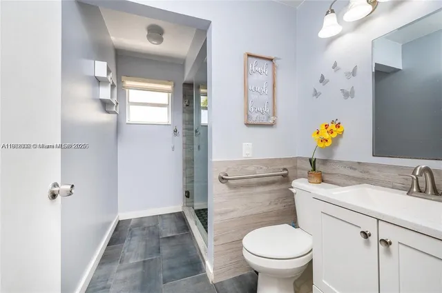 a bathroom with a toilet sink vanity and mirror