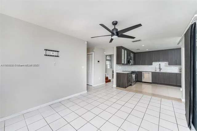 a large white kitchen with a sink stainless steel appliances and cabinets