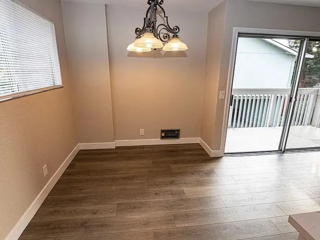 a view of a livingroom with wooden floor and a window