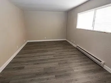 a view of a room with wooden floor and window