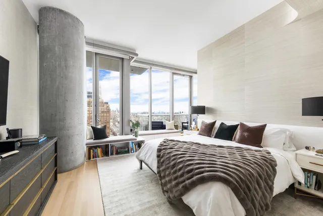 a bedroom with a bed and a large window