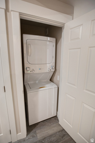 983 South 950 West Provo, UT 84601 - Photo 39 of 56 Stackable washer and dryer unit within a dedicated closet, featuring a paneled door and wood-finish flooring