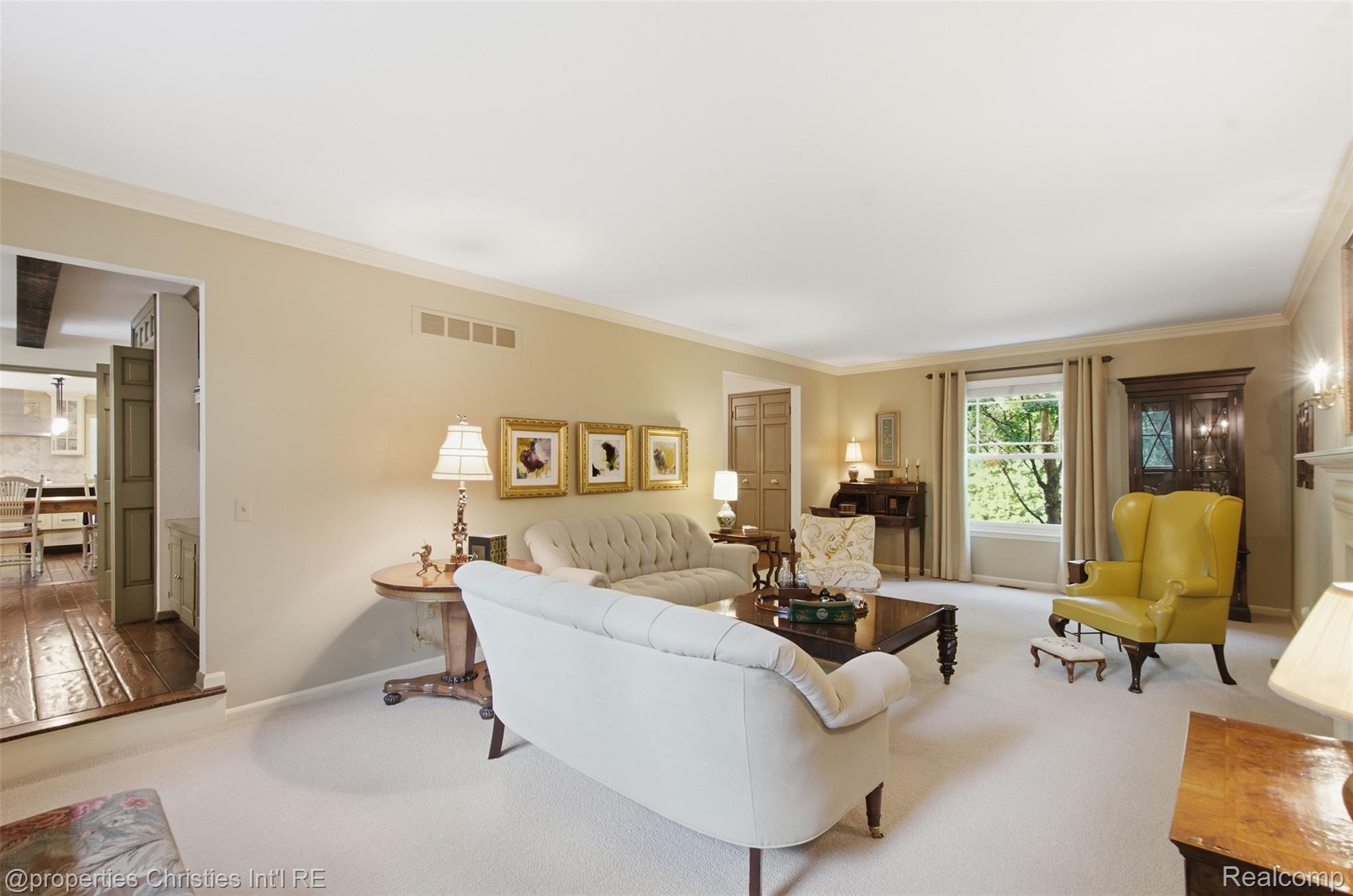 25235 Canterbury Road Franklin, MI 48025 - Photo 8 of 56 Spacious living room featuring crown molding, neutral carpeting, and a large window with exterior views