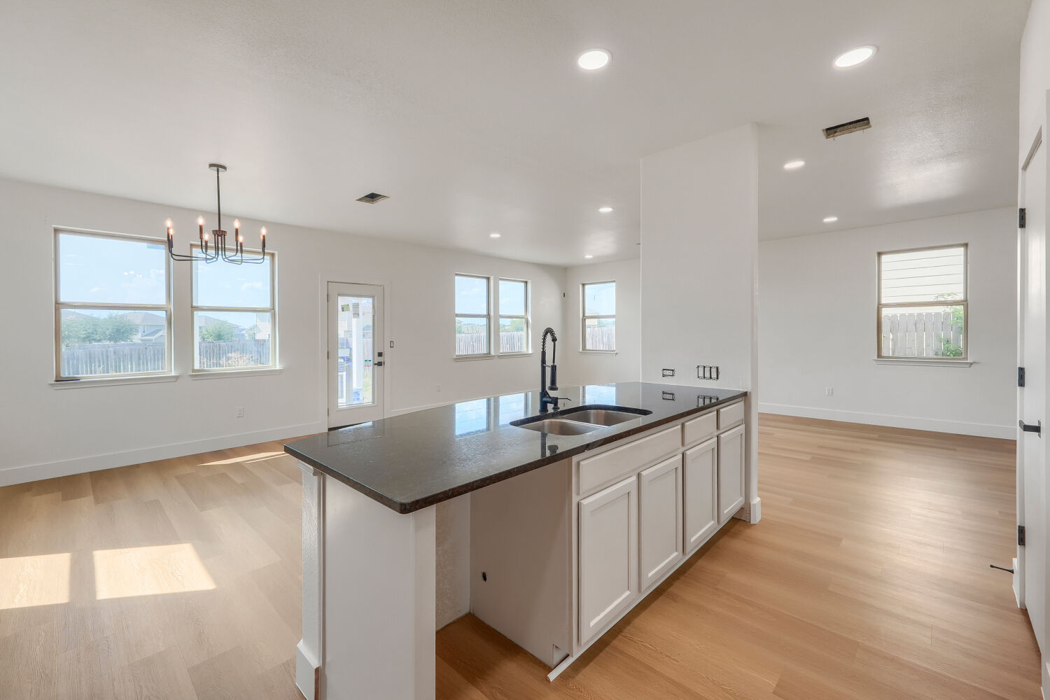 320 Triumph Road Buda, TX 78610 - Photo 22 of 22 An open floorplan seamlessly connects the airy kitchen and dining spaces over wood flooring.