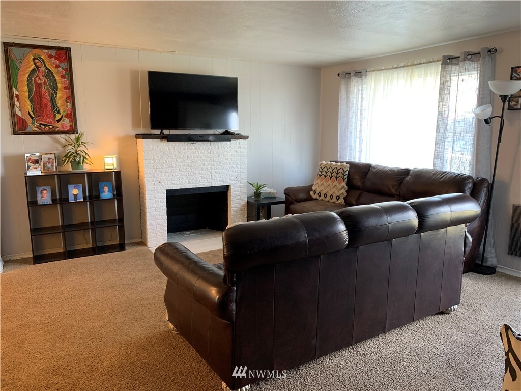 353 Maringo Road Ephrata, WA 98823 - Photo 8 of 20 a living room with furniture a flat screen tv and a fireplace