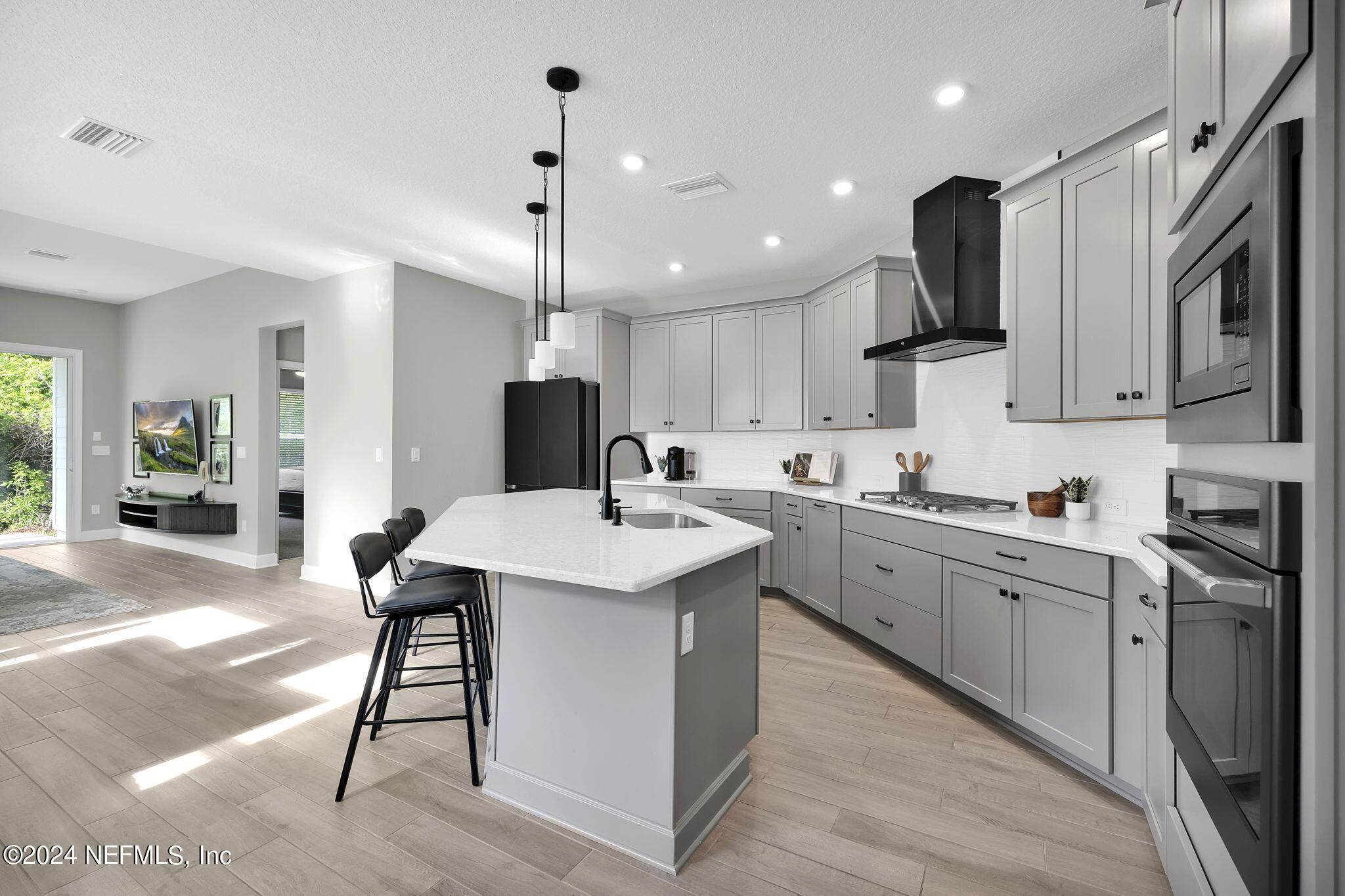 175 Windswept Way Street St. Augustine, FL 32092 - Photo 6 of 80 a kitchen with stainless steel appliances kitchen island granite countertop a sink a stove a refrigerator and island with wooden floor